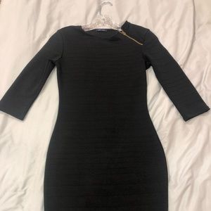 Black midi dress with zipper on shoulder.